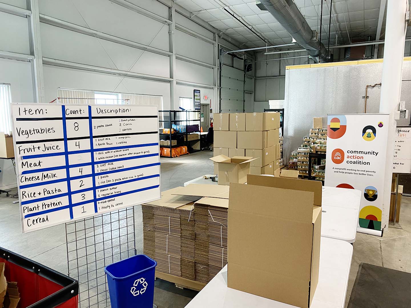 warehouse with boxes and a chart with food items listed